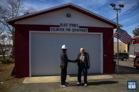 William Lobster Jr. and Dan Coppa shake hands in front of the Northern Nevada African American Firefighter Museum on Feb. 26, 2022 in Reno, Nev. Their fathers had done the same in 1970 when the building was the Black Springs Volunteer Department. Image: Ty O'Neil / This Is Reno