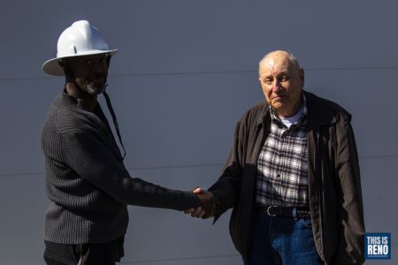 William Lobster Jr. and Dan Coppa shake hands in front of the Northern Nevada African American Firefighter Museum on Feb. 26, 2022 in Reno, Nev. Their fathers had done the same in 1970 when the building was the Black Springs Volunteer Department. Image: Ty O'Neil / This Is Reno