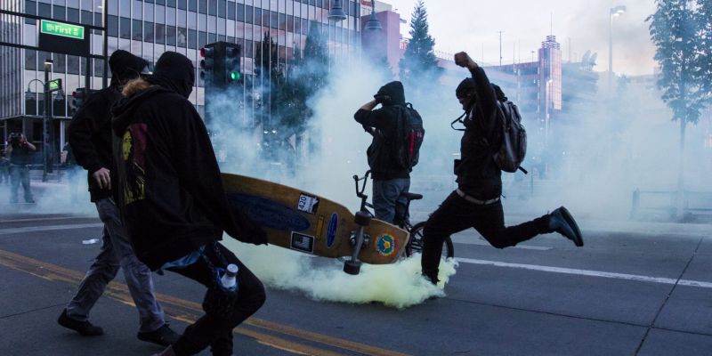 Rioters kick gas canisters back toward police. Image: Ty O'Neil