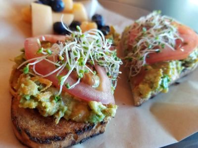 Avo toast with tomatoes and sprouts at The Mug Shot Coffee & Eatery