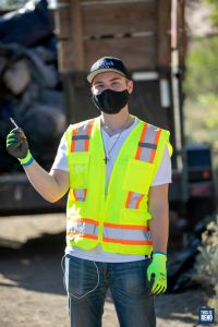 A member of the clean-up crew holds a used syringe from a camp near Interstate 80. Image: Eric Marks