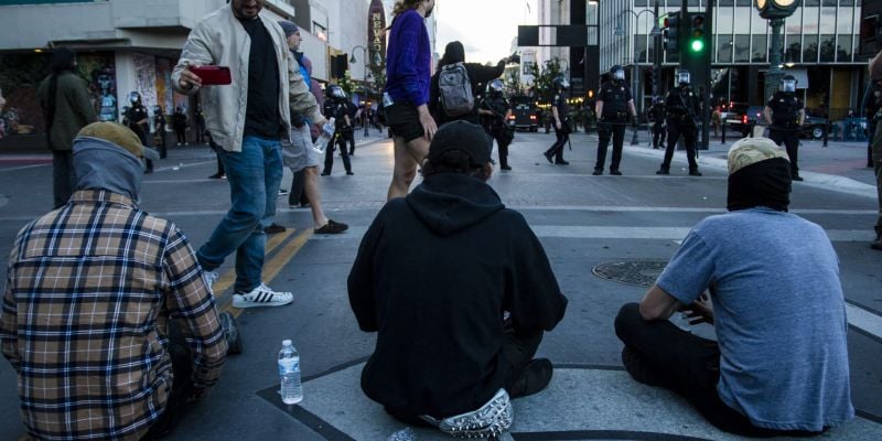 Protesters sit in the middle of the street during a riot in downtown Reno.