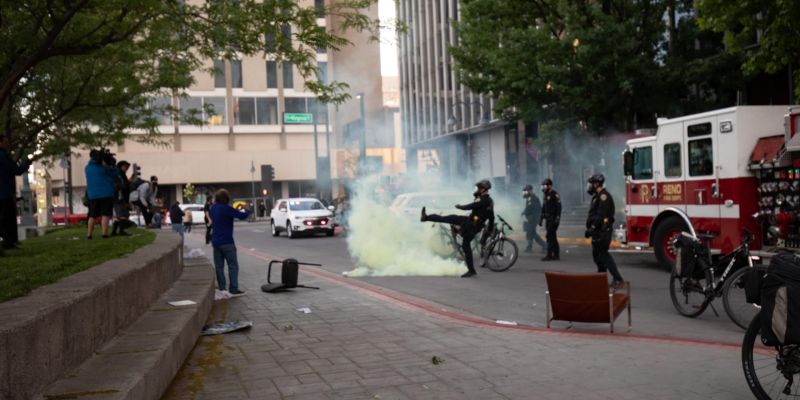 Reno Police kick tear gas toward rioters in downtown Reno. Image: Isaac Hoops