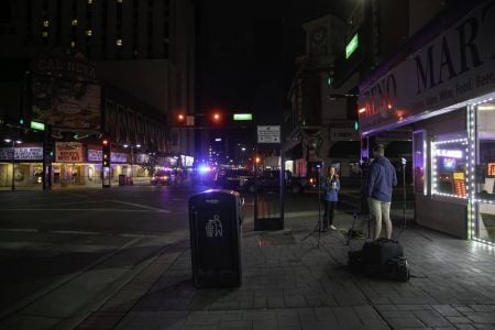 A news reporter broadcasts from a nearly empty downtown Reno after a 5:30 p.m. curfew was established for the night. Image: Eric Marks