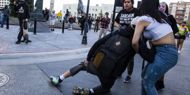 A rioter is carried away by friends after being hit by a rubber bullet shot by Reno Police. Image: Ty O'Neil