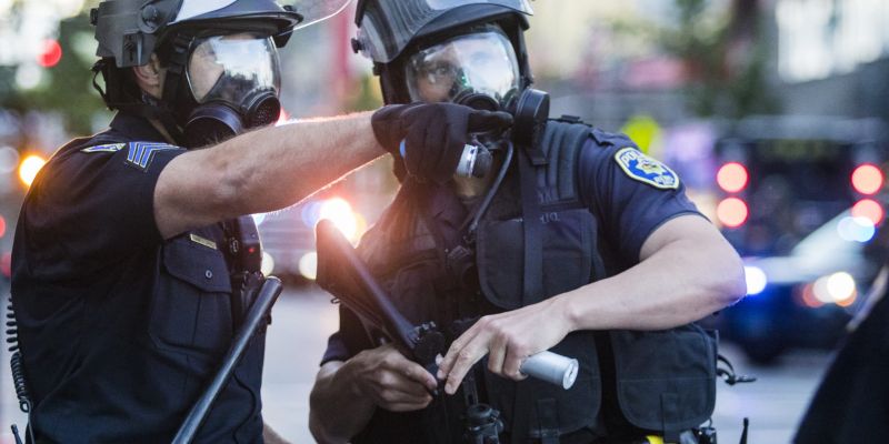 Police wearing gas masks load rubber bullets into their guns. Image: Ty O'Neil