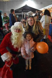 santa poses with a young girl and her mother