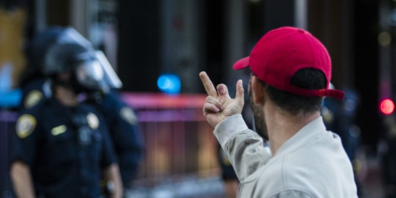 A protester flips off police officers. Image: Ty O'Neil